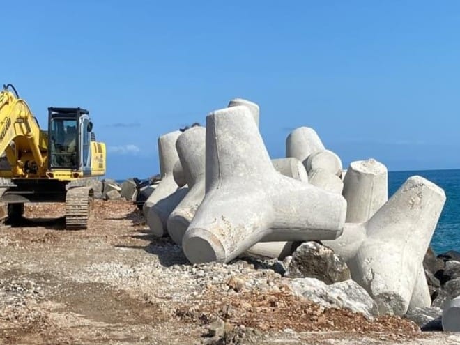 Posizionamento di tetrapodi in calcestruzzo armato su mantellata per difesa costiera