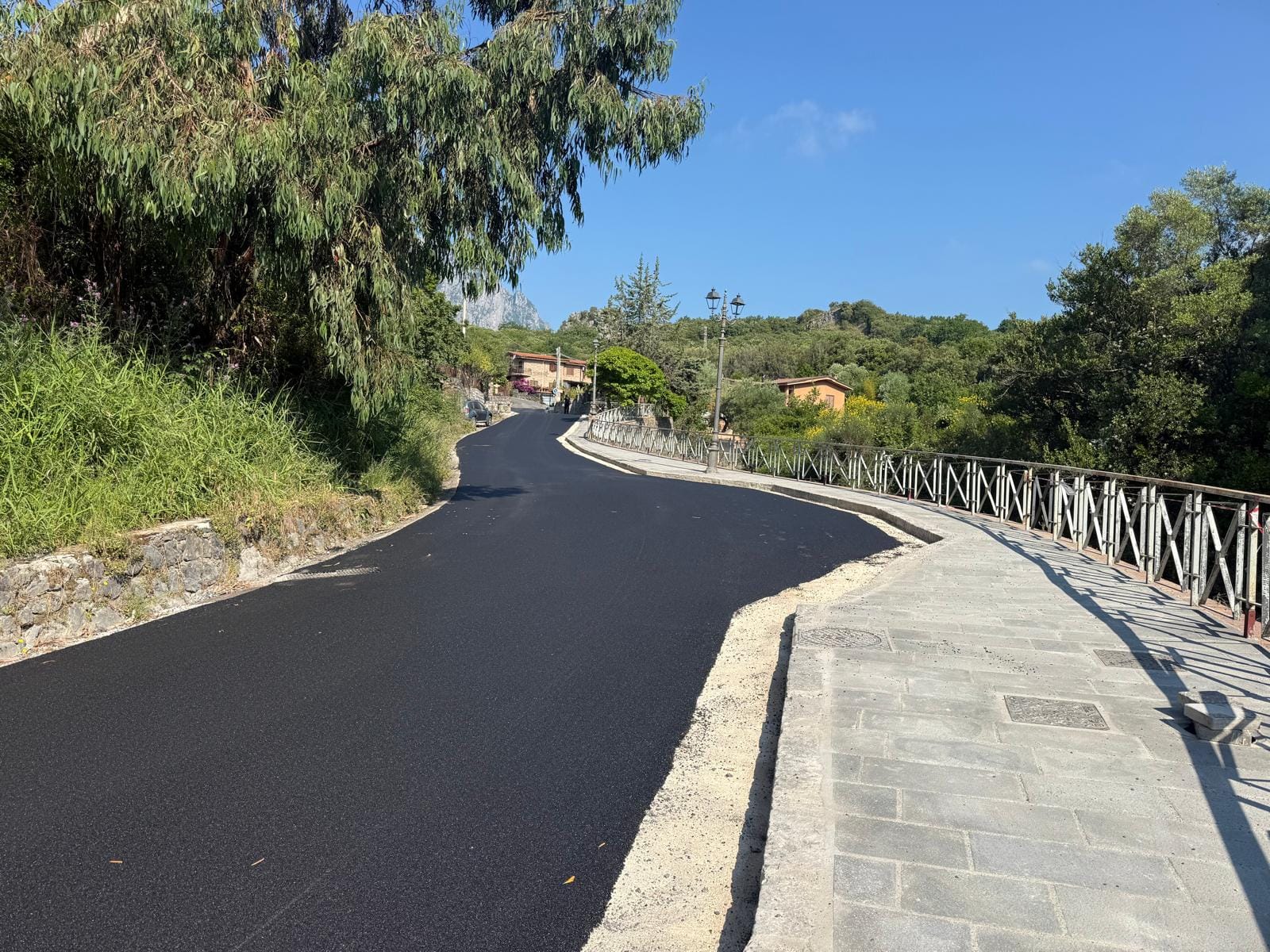 Strada asfaltata con marciapiede lungo il Vallone San Luca a Scario dopo l’intervento